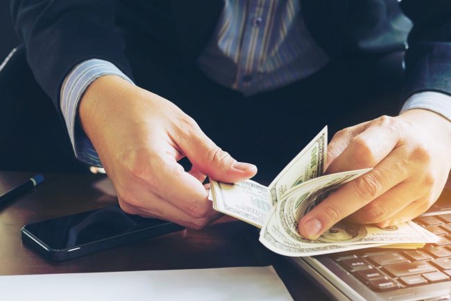 Business man counting dollar banknote – online business concept 5 tips to protect your business from internal theft