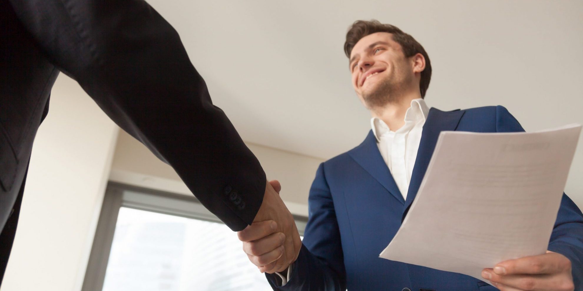 Image of two men shaking hands illustrates blog: "3 Ways to Improve the Candidate Experience"