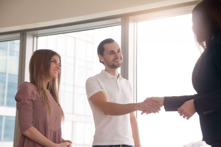 Photo of woman and man shaking hands illustrates blog: "Seasonal Hiring for the Holidays: What You Need to Know"