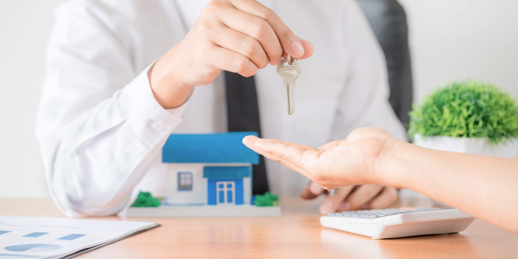 Photo of man handiing keys to another person illustrates blog: "Tenant Screening: What You Need to Know"