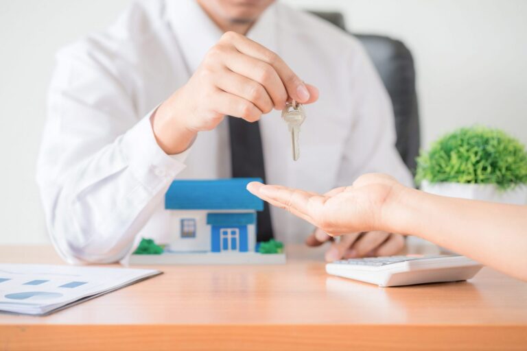 Photo of man handiing keys to another person illustrates blog: "Tenant Screening: What You Need to Know"