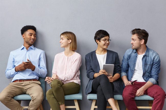 Photo of job candidates sitting next too each other illustrates blog: "Rapid Hiring: How to Do It Safely"