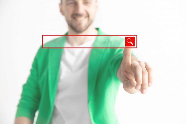 Photo of man pressing search engine button illustrates blog: "The Google Approach to Hiring and Job Interviews"