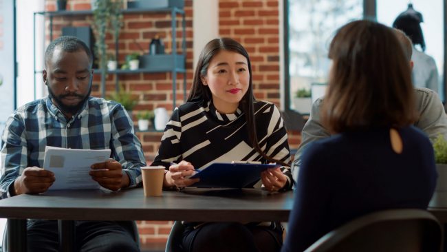 Photo of man and woman conducting job interview illustrates blog: "For How Long is a Background Check Good?"