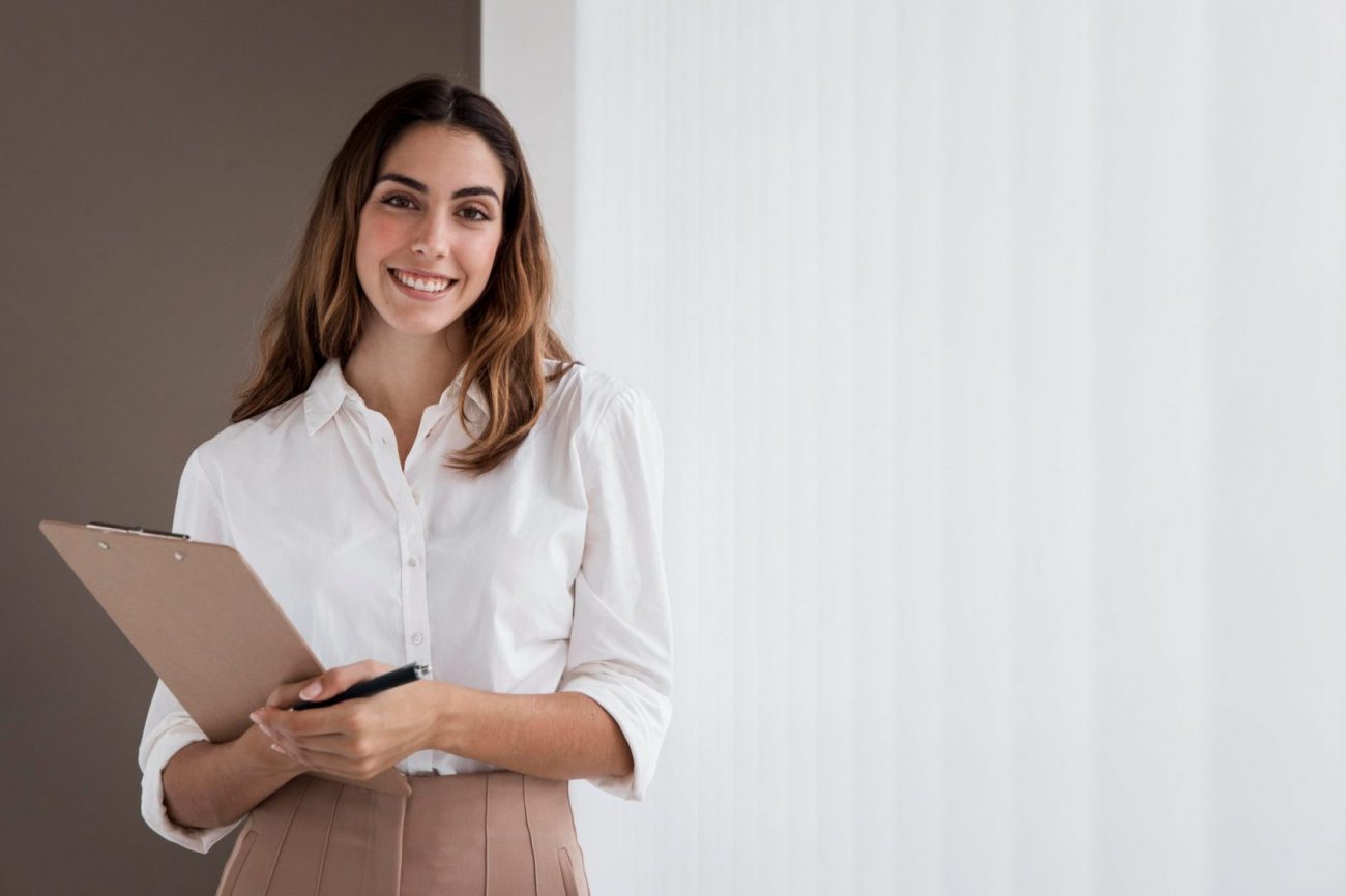 Photo of female administrative assistant with clipboard.