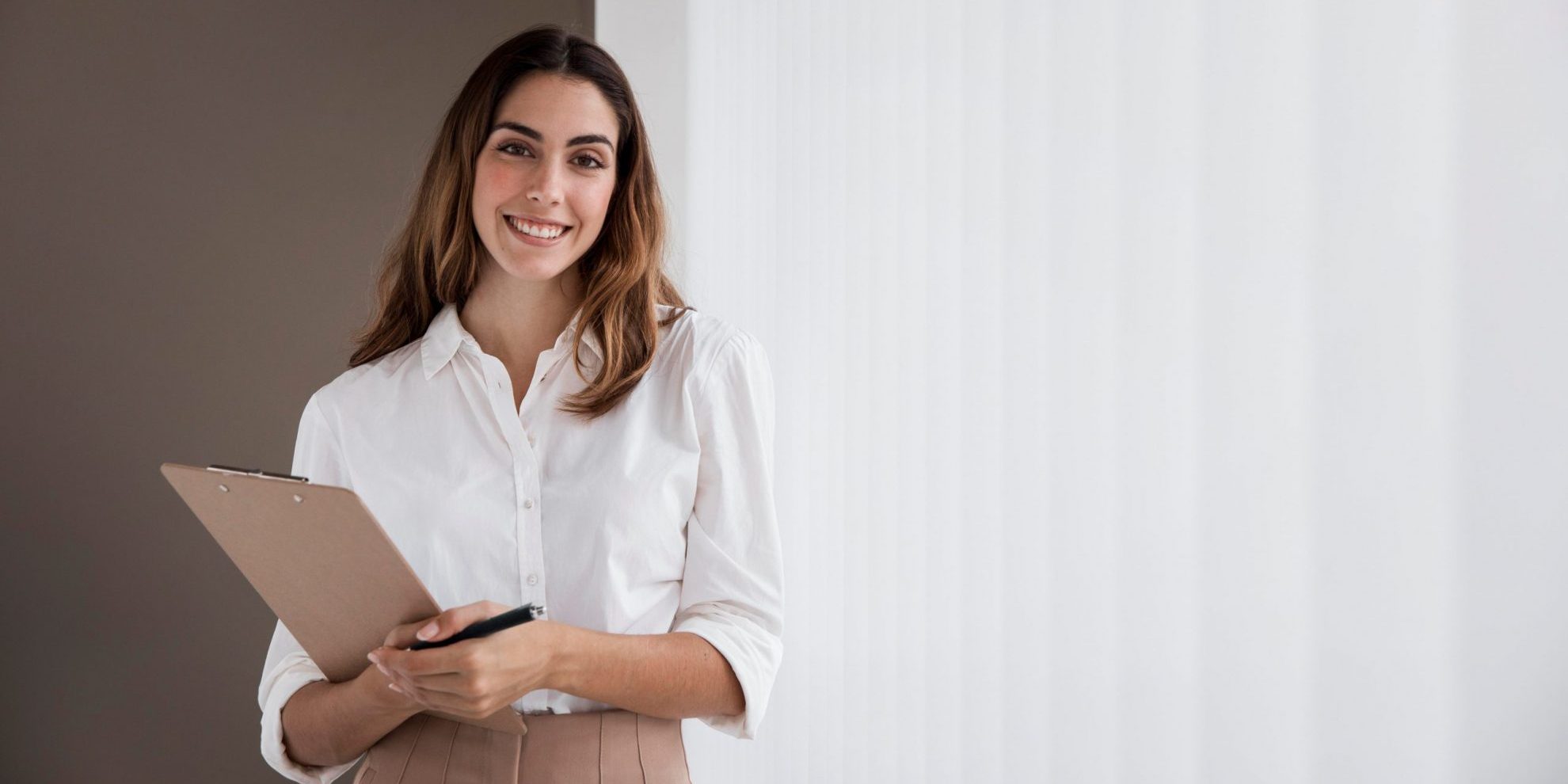 Photo of female administrative assistant with clipboard.