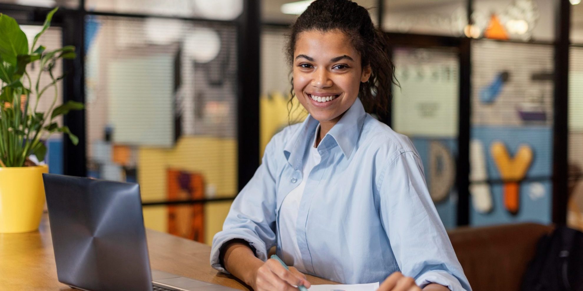 Photo of smiling girl with laptop illustrates blog; "4 Strategies to Increase Employee Retention"