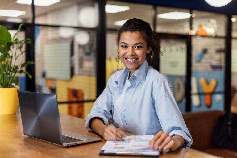 Photo of smiling girl with laptop illustrates blog; "4 Strategies to Increase Employee Retention"
