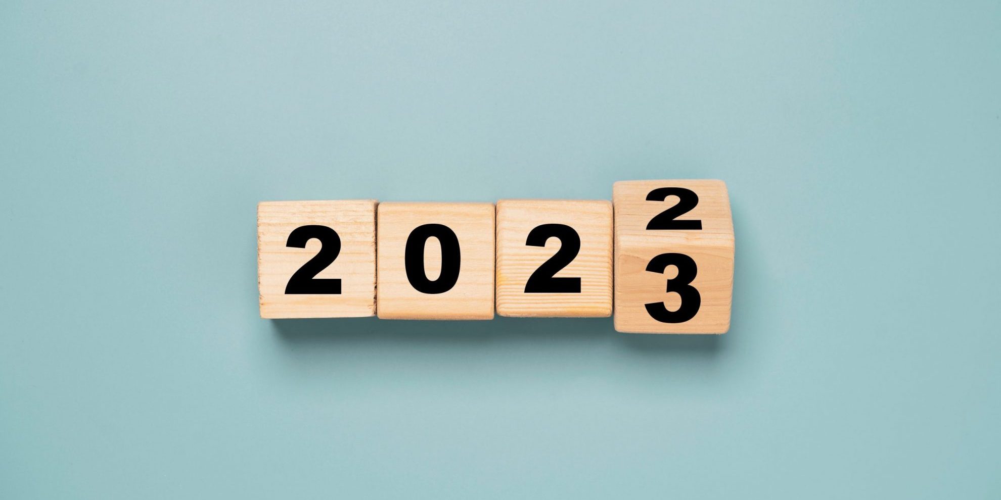 Wooden cubes that show the date changing from 2022 to 2023 illustrates blog: "4 Workplace Trends To Watch in 2023"