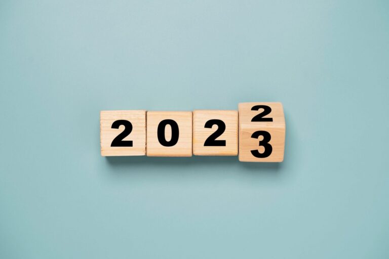 Wooden cubes that show the date changing from 2022 to 2023 illustrates blog: "4 Workplace Trends To Watch in 2023"