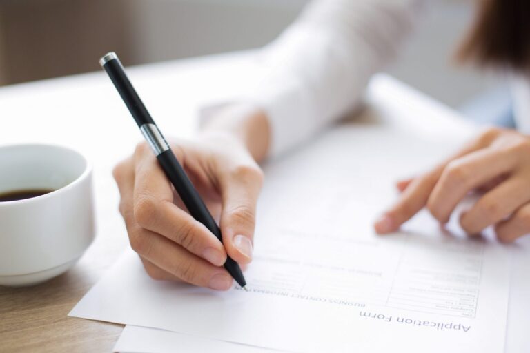 Photo of person writing illustrates blog: "Do Background Checks Show Employment History?"