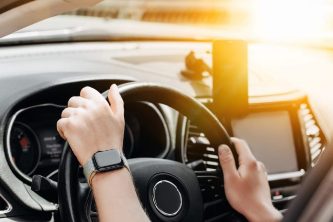 driving Closeup of person holding steering wheel illustrates blog "Will a Background Check Show a DUI?"