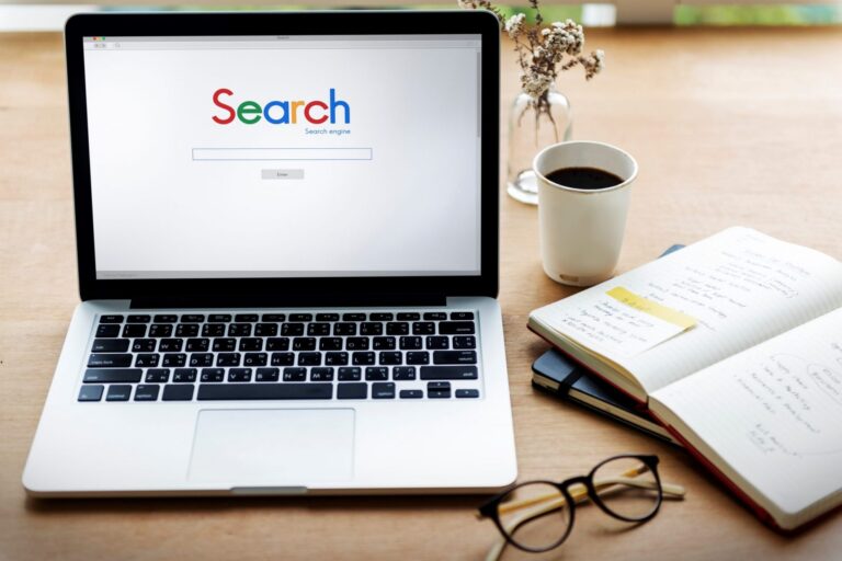 Photo of laptop with words "Search" displayed on the screen.