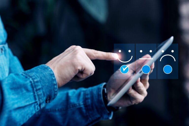Closeup of man holding tablet with overlay of smiley face, neutral face, and sad face illustrates blog "What Is Brand Reputation and Why It Matters"