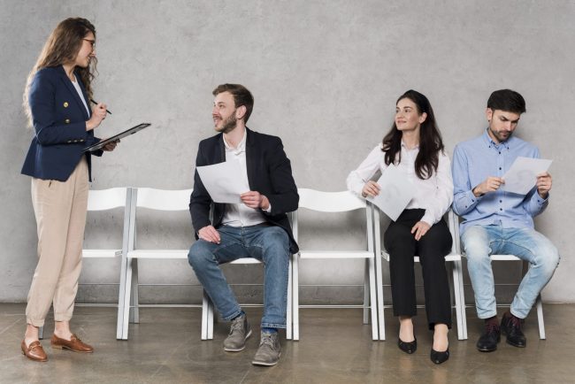 Woman talking to job candidates illustrates blog "How to Avoid Hiring Mistakes"