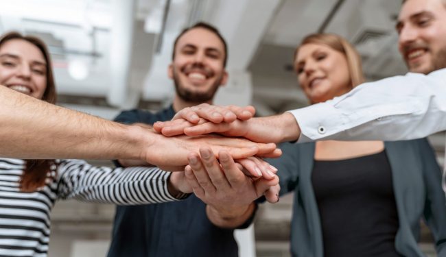 InternalHiring Group of people joining hands illustrates blog "5 Tips to Get Internal Hiring Right"