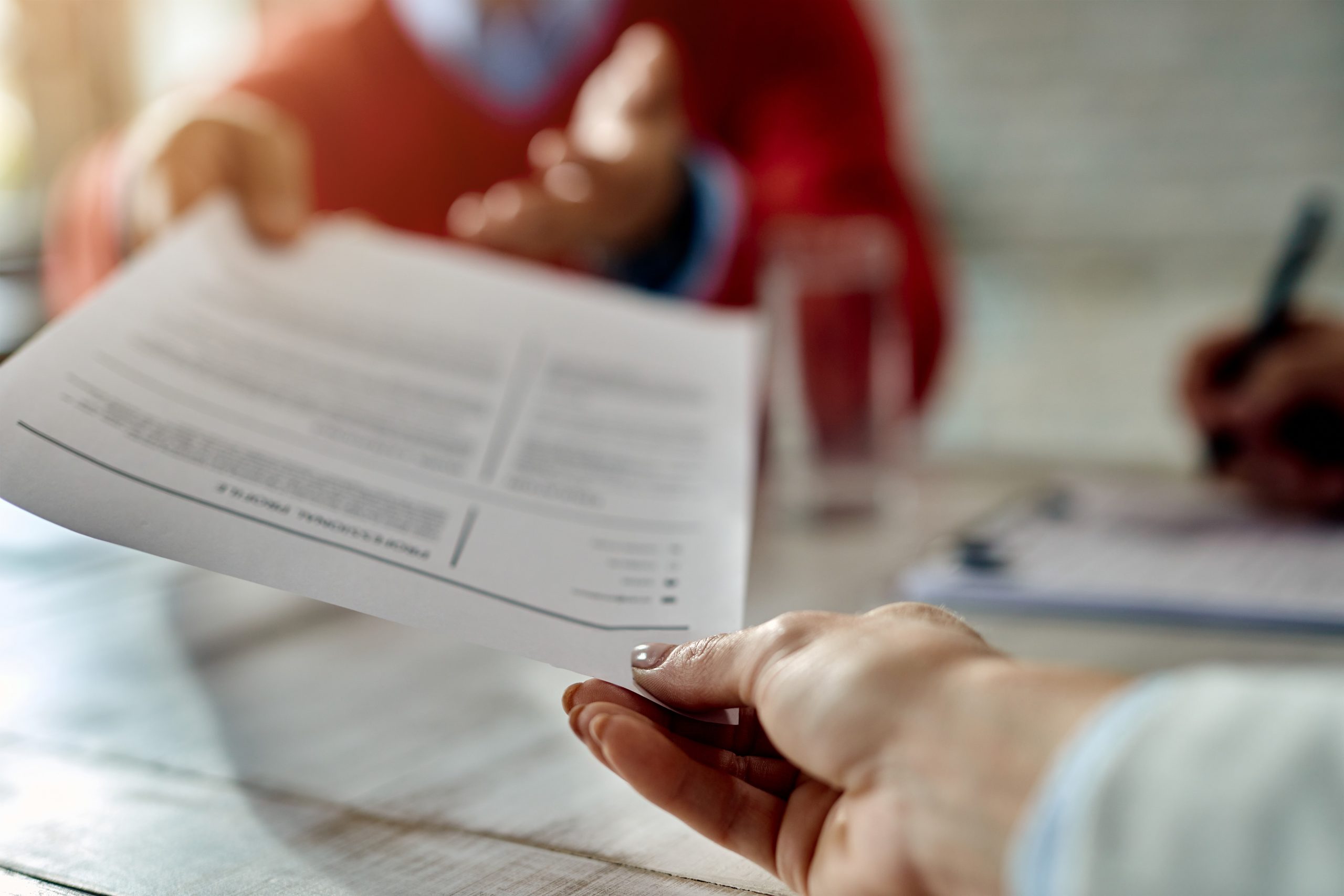 Closeup of person handing resume.
