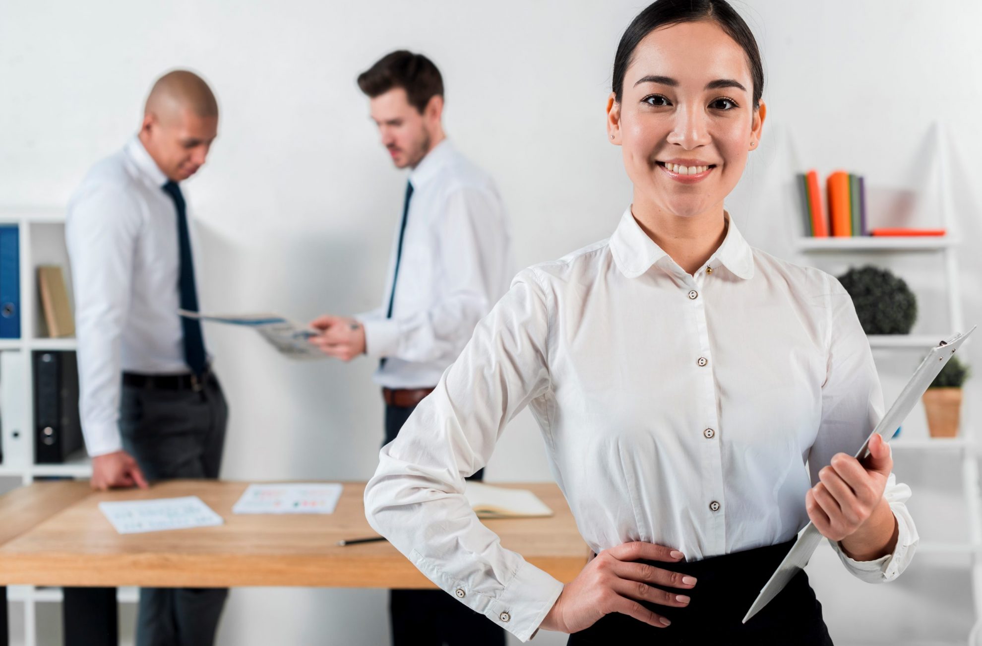 Woman in business attire holding clipboard illustrates blog "Workplace Trends: What is the Big Stay?"