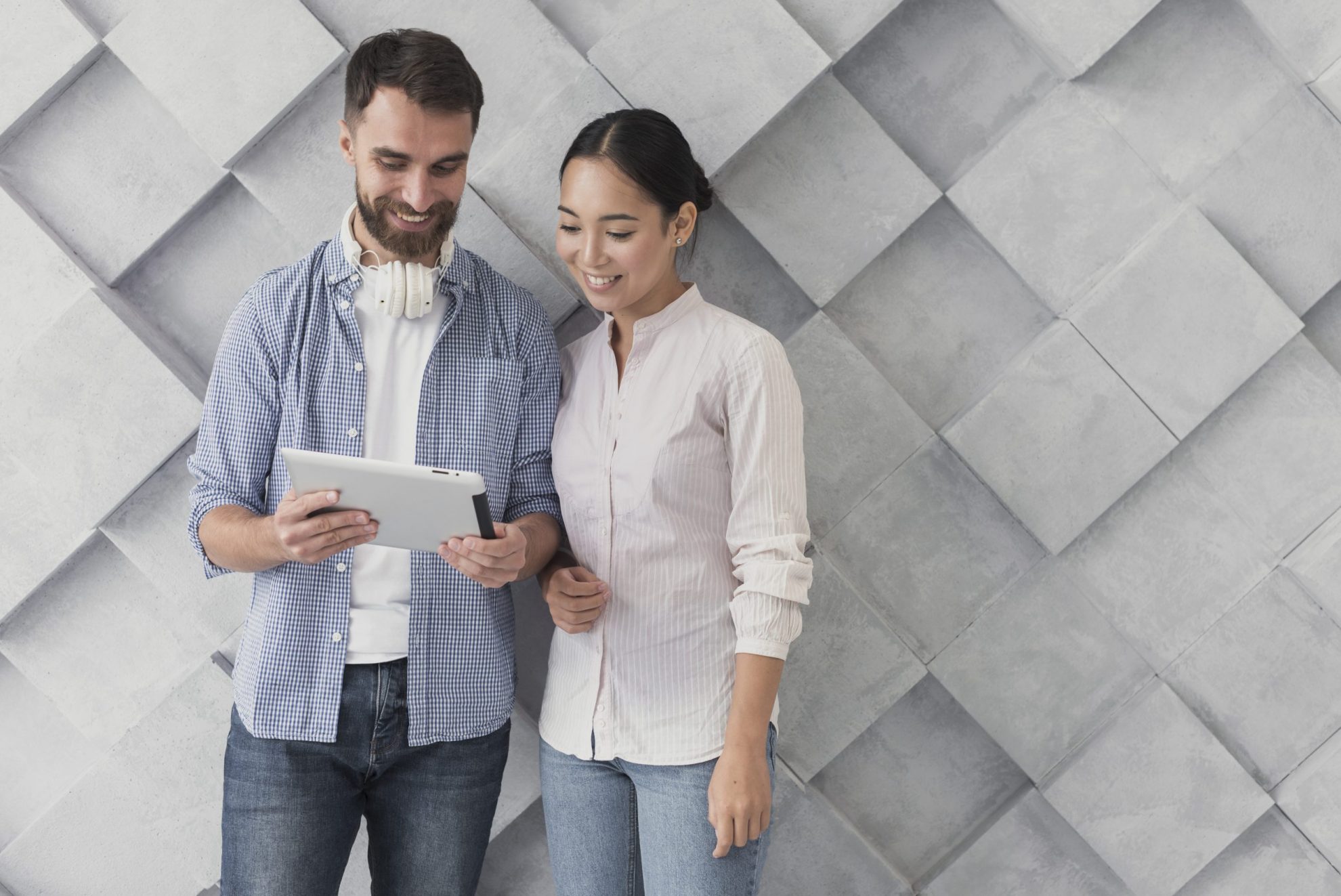 Man and woman looking at tablet illustrate blog "How to Evaluate a Candidate's Soft Skills"