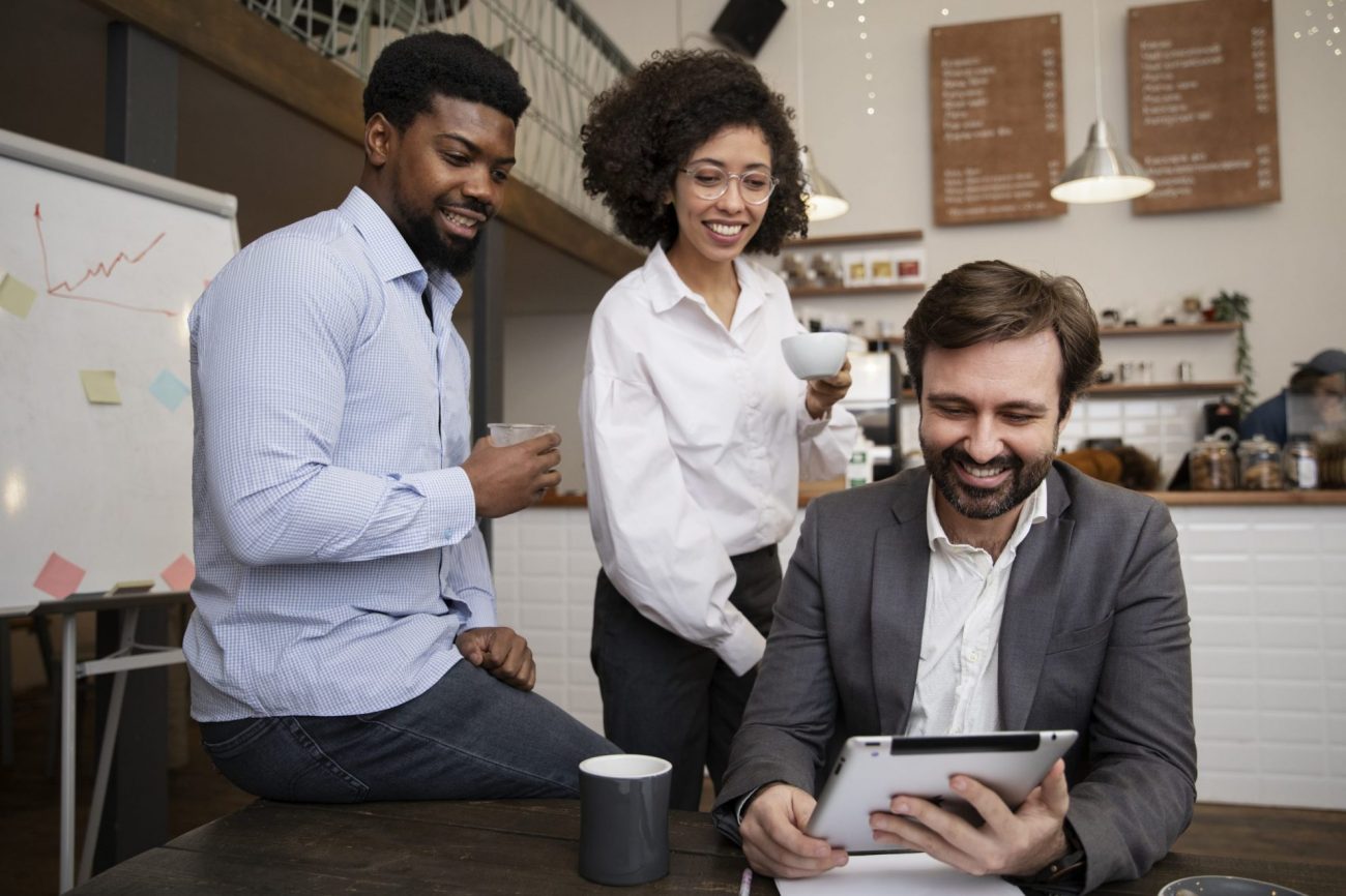 workplace-DEI-fp Group of three people looking at tablet illustrates blog "What Is DEI in the Workplace?"