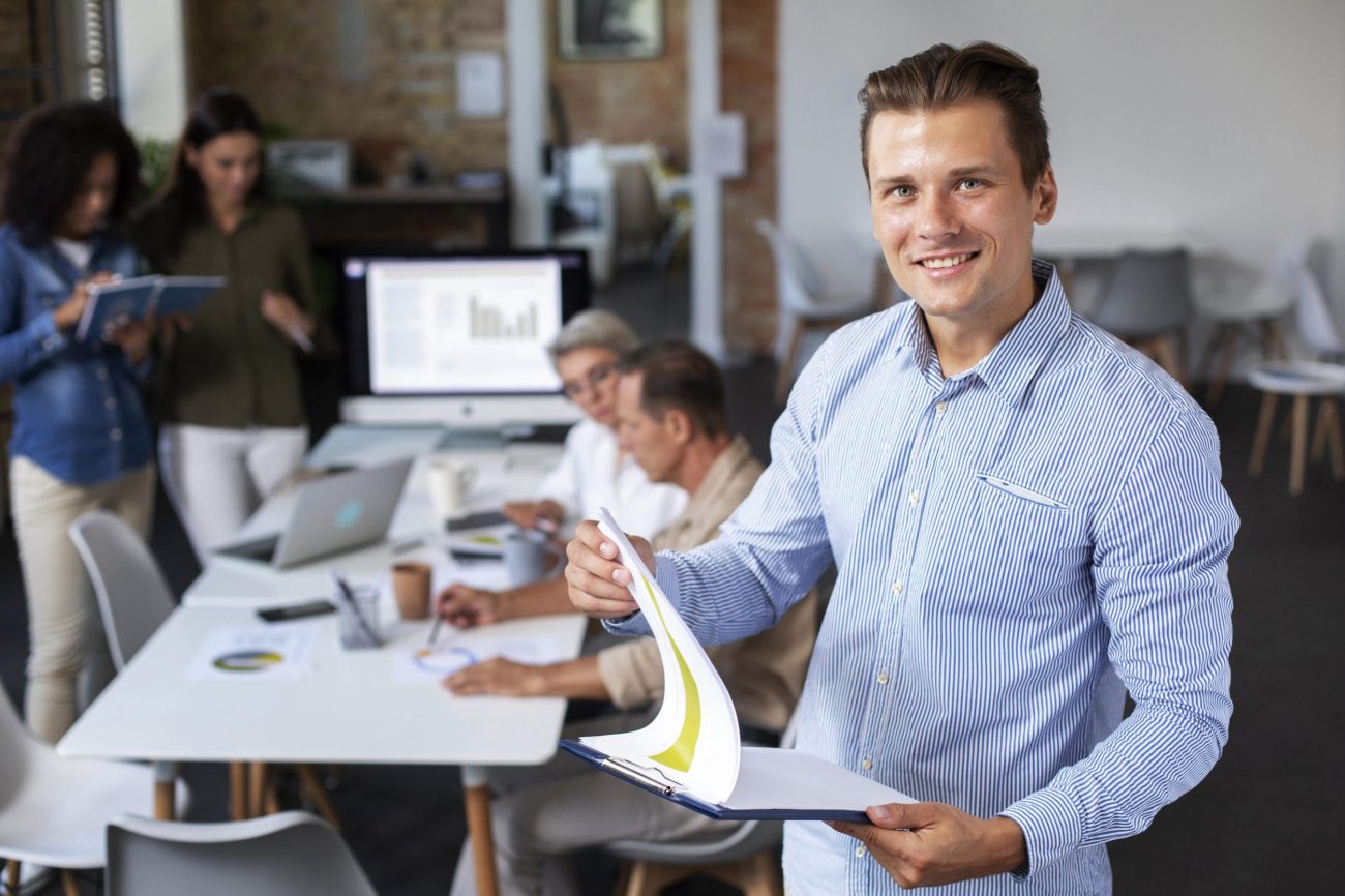 employee-office-fp Man in office holding clipboard illustrates blog "Internal Gigs and Background Screening"