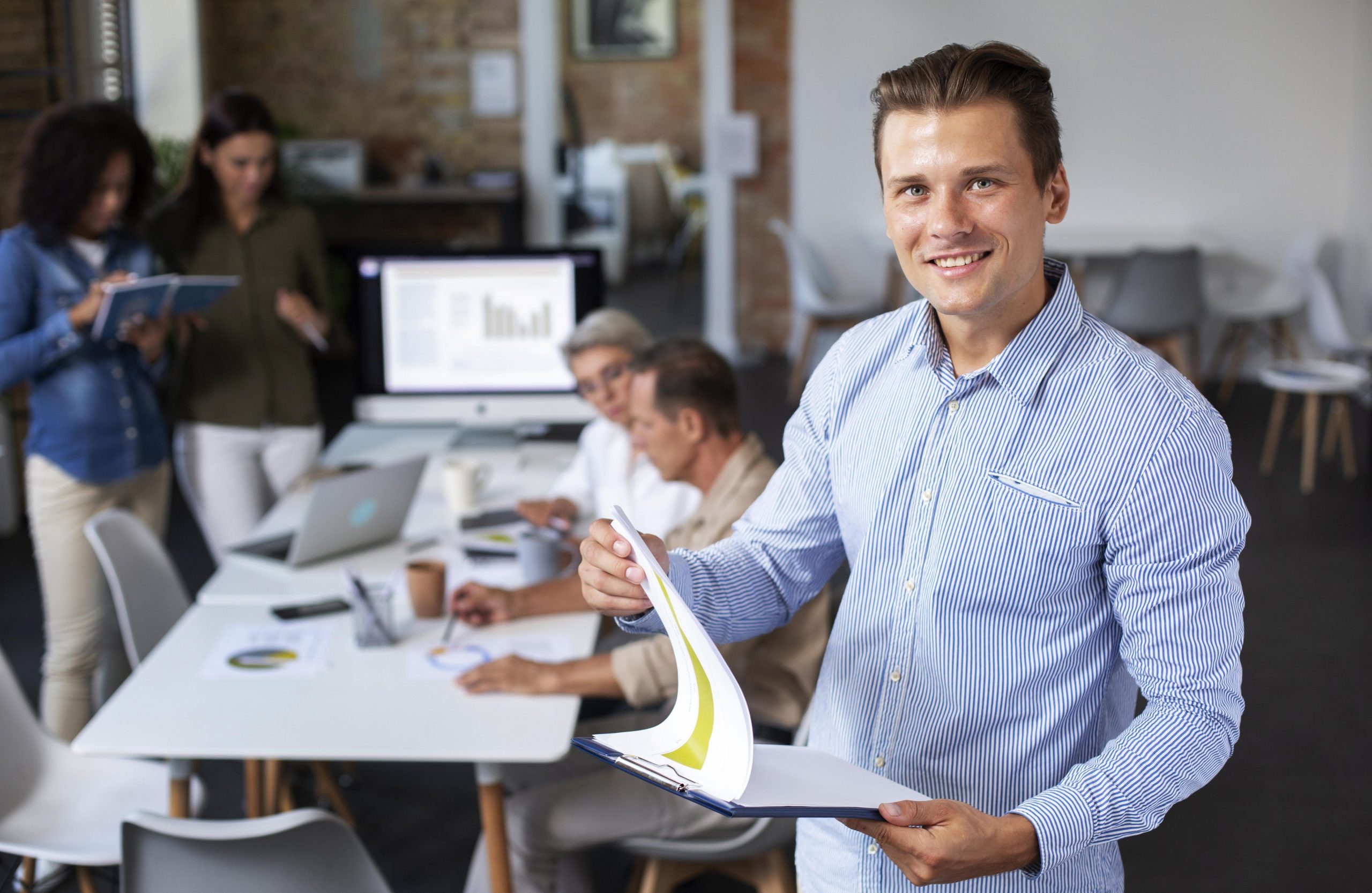 Man in office holding clipboard illustrates blog "Internal Gigs and Background Screening"