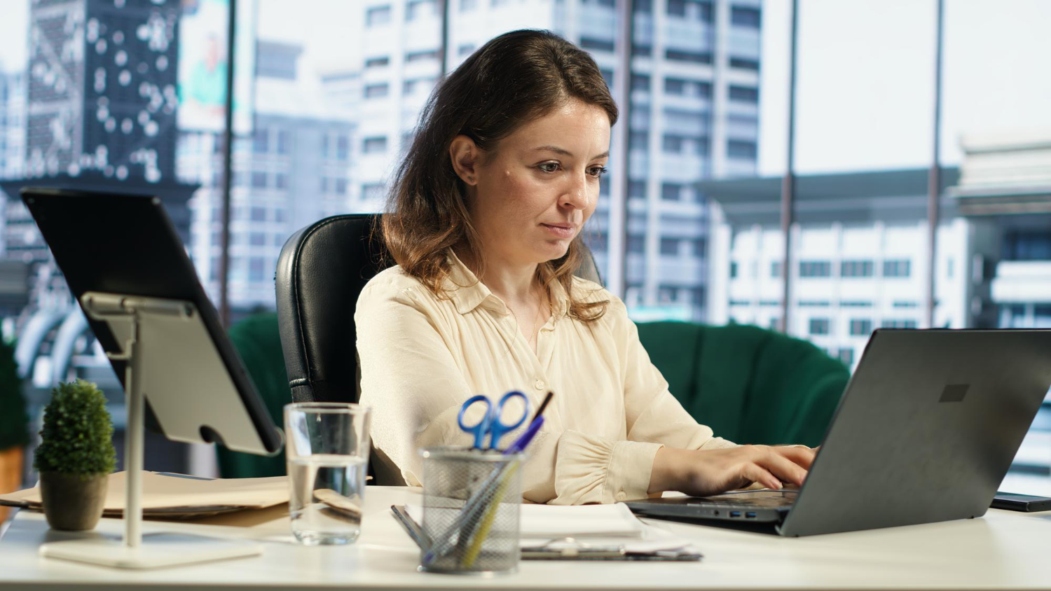 124877 HR manager handling multi-state hiring compliance documents on laptop