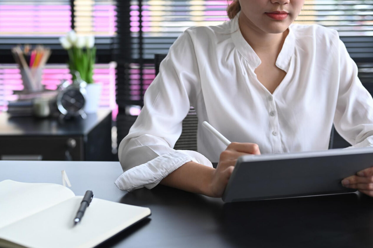 cropped-shot-office-worker-using-digital-tablet-office-desk HR manager reviewing background check compliance documents on laptop